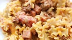 closeup of pasta with meat and cheese on white plate