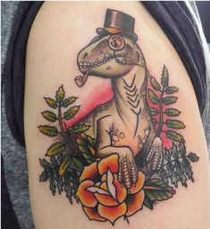 a person with a tattoo on their arm that has a lizard wearing a top hat and holding a rose