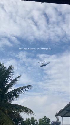 an airplane is flying in the sky above some palm trees and a building with a sign that says, but then it passes, as all things do