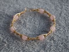 Check out this beautiful hand wrapped bracelet with a harmonious blend of elegance and charm. Genuine rose quartz beads, known for their soothing energy, are delicately accented by hand wrapped gold-colored wire (tarnish resistant copper wire). Elevate your style with the timeless beauty of natural gemstones and handcrafted artwork. Wire Wrapped Beaded Bracelet, Wire Wrapped Pearl Bracelet, Gold Wire Bracelet, Wire Wrapped Bead Bracelet, Dainty Wire Wrapped Jewelry, Cute Homemade Bracelets, Copper Bracelets Handmade, Wire Bracelet Ideas, Bead Wire Jewelry