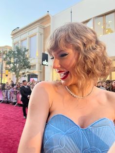 taylor swift on the red carpet at the 2013 oscars wearing a blue strapless dress