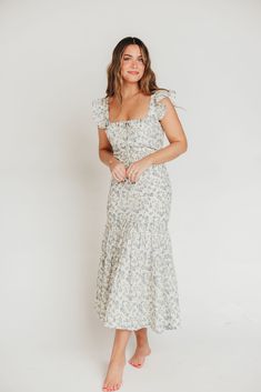 Whether you're frolicking through a field of wildflowers, touring a sunny Greek isle, or attending a springtime baby shower, the Emery Midi Dress will ensure you do it looking like a goddess. We designed this premium dress with an ultra-flattering neckline and a figure-skimming silhouette, paired with a flounced skirt and sweet ruffle details. The Emery is guaranteed to be one of your most feminine (and most favorite!) pieces. FIT: Runs very fitted. This dress is designed with a fit-and-flare pr Spring Maxi Length Dresses For Picnic, Maxi Length Dress For Spring Picnic, Fitted Maxi Dress With Ditsy Floral Print For Spring, Flowy Ditsy Floral Sundress For Garden Party, Flowy Floral Print Cottagecore Dress, Bohemian Floral Print Dress For Picnic, Bohemian Ditsy Floral Print Dress For Spring, Bohemian Ditsy Floral Dress For Spring, Bohemian Floral Print Dresses For Picnics