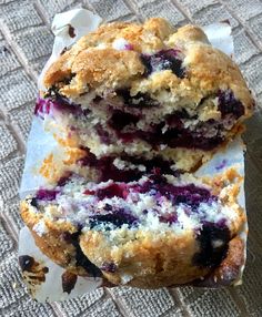 two blueberry muffins cut in half sitting on top of a piece of paper