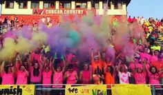 a group of people standing in front of a crowd with colored powder