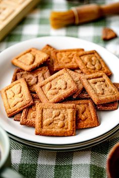 a white plate topped with cookies on top of a checkered tablecloth covered table