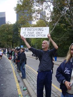 a man holding up a sign while standing next to other people on the side walk