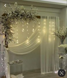 a white wedding arch decorated with flowers and lights