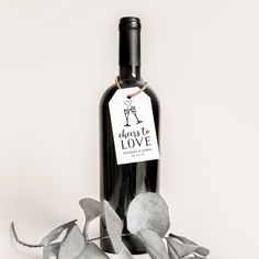 a bottle of wine with some silver leaves around it