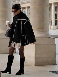 Chic Winter Fringe Outerwear, Winter Long Sleeve Outerwear With Tassels, Winter Outerwear With Tassels And Long Sleeves, Fringe Long Sleeve Outerwear For Winter, Winter Cape With Tassels, Winter Fringe Cape Outerwear, Oversized Long Sleeve Fringe Outerwear, Black Fringe Outerwear For Winter, Black Fringed Outerwear For Winter