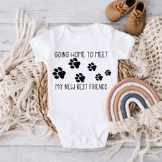 a baby bodysuit that says, going home to meet my new best friends with paw prints