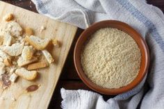 a wooden cutting board topped with food next to a bowl of breadcrumbs