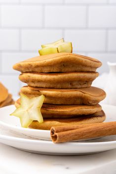 a stack of pancakes with apple slices and cinnamon sticks