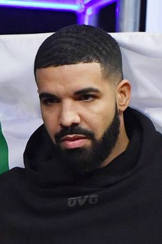 a close up of a person wearing a hoodie with a flag in the background