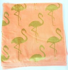 an orange towel with pink and green flamingos on it