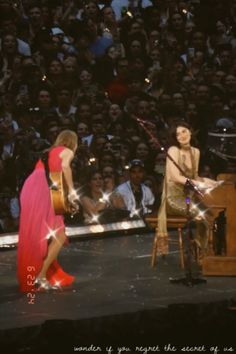 two women are performing on stage in front of an audience