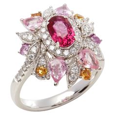 This ring designed by David Jerome is from his private collection and features one oval cut Ruby sourced in Mozambique Totalling 1.08cts. Set with a mix of round brilliant cut Diamonds, pink and yellow Sapphires totalling 1.94cts combined. Mounted in platinum. Ring size UK N, EU size 54, USA size 6 1/2. David prides himself in only sourcing the finest and most exclusive gemstones whose natural beauty and colour enhance the settings he creates for each piece. These exclusive designs offer buyers Luxury Pink Multi-stone Sapphire Ring, Luxury Pink Multi-stone Ruby Ring, Pink Sapphire Multi-stone Ring With Diamond, Pink Multi-stone Sapphire Diamond Ring, Pink Multi-stone Sapphire Ring With Diamond, Luxury Pink Oval Cluster Ring, Multicolor Oval Diamond Ring For Formal Occasions, Formal Multicolor Oval Diamond Ring, Gia Certified Oval Pink Diamond Ring