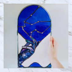 a hand is holding up a stained glass window