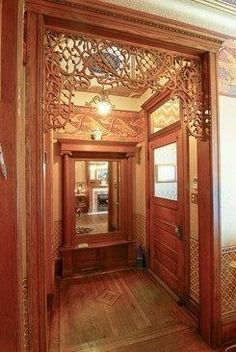 an ornately decorated hallway with wooden floors and walls is pictured in this image from the front door