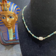 A 17.5 inch long ancient Egyptian necklace featuring blue faience tubular and disc shaped beads.  Hanging from the faience necklace is a steatite scarab that represents the Sun God, Ra, and is symbol of rebirth and regeneration.  Circa 300 to 50 BC Egyptian Necklace, Egyptian Scarab, Sun God