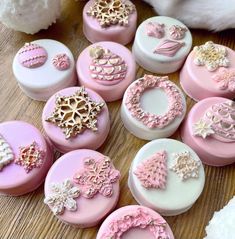 pink and white decorated cookies sitting on top of a wooden table