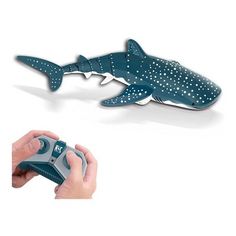 a person holding a game controller in front of a shark