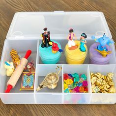 a plastic container filled with lots of toys and confetti on top of a wooden table