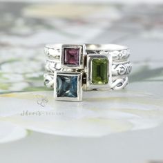 This listing includes one 4x4mm square gemstone and one 6x4mm emerald/octagon shaped gemstone and one 5x5mm square gemstone. All gems are set in a sterling silver bezel setting on a sterling silver stacking ring of your choice. These settings are quite tall so contact me for measurements if you are unsure if you'd love a tall setting.  Gemstones included are listed below. Gems are natural unless otherwise indicated. I offer a wide variety of natural gems for each month, contact me for prices. Th Sterling Silver Birthstone Ring, Family Ring, Birthstone Rings, Family Rings, Sterling Silver Stacking Rings, Stacking Ring Set, All Gems, Silver Stacking Rings, Step Cut