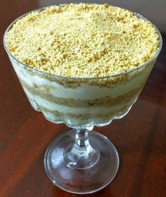 a dessert in a glass on top of a wooden table