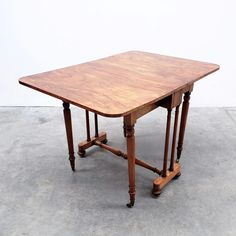 an old wooden table sitting on top of a cement floor