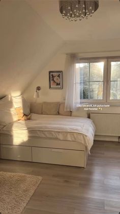 a bedroom with white walls and wooden floors