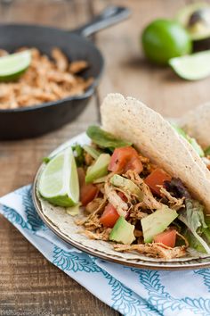 two tortillas filled with shredded meat, avocado and tomatoes