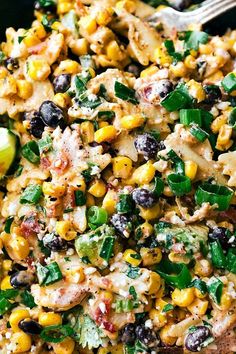 corn salad with black olives, green onions and cilantro in a bowl