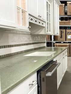 a kitchen filled with lots of white cupboards and counter top space next to a dishwasher