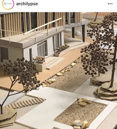 a model of a building with trees and rocks in the ground next to each other