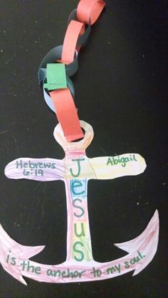 an anchor made out of colored paper on a black surface with words written in different languages