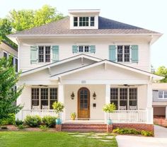 a white two story house with blue shutters