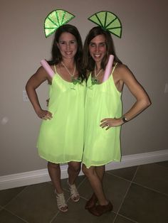 two women in green dresses standing next to each other