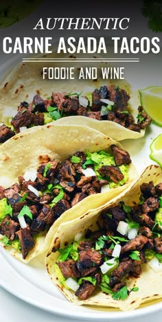 three tacos on a plate with limes and cilantro in the background