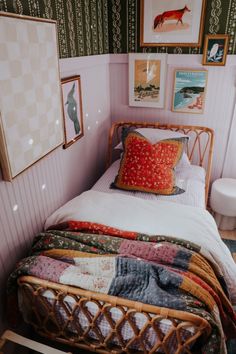 a small bed in a room with pictures on the wall