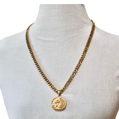 Unleash your inner strength and regality with the Cersei Amulet Necklace, a bold statement piece that exudes power and elegance. This luxurious necklace features a finely detailed lion emblem on a round pendant, symbolizing courage and authority. The pendant hangs from a sturdy, gold-plated curb chain that gleams with a rich luster, making it a standout accessory for any occasion. The necklace is completed with a sleek spike charm that adds an edgy touch, perfect for those who appreciate a mix o Spiritual Medallion Jewelry With Box Chain, Amulet Style Medallion Jewelry With Box Chain, Gold-tone Medallion Chain Jewelry, Stainless Steel Medallion Jewelry With Adjustable Chain, Brass Medallion Chain Jewelry, Metal Medallion Jewelry With Chain, Metal Medallion Chain Jewelry, Spiritual Jewelry With Round Pendant Chain, Spiritual Round Pendant Chain Jewelry