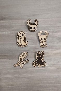 four wooden stickers with different designs on them, one has a skull and the other is