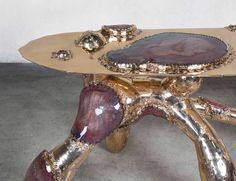 a gold and purple table sitting on top of a cement floor