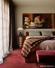 a bedroom with red carpet and two paintings on the wall