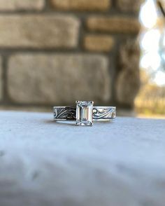 a close up of a ring with a stone in the middle and a brick wall behind it