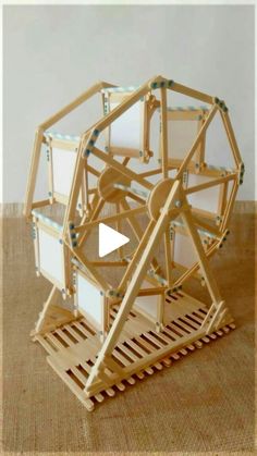 a wooden structure that has been made to look like a ferris wheel and is on the floor