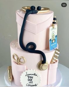 a pink cake with gold accents and a doctor's stethoscope on top