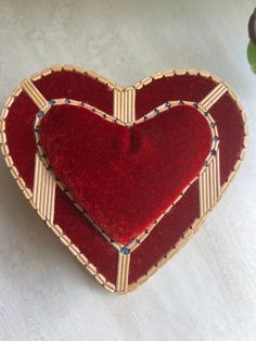 a red heart shaped cushion sitting on top of a table