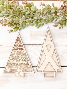 two wooden christmas trees sitting next to each other on top of a white wood table