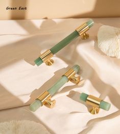 three green and gold handles on a white sheet