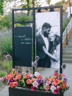 an outdoor ceremony with flowers and a photo on the back of a sign that says mr and mrs